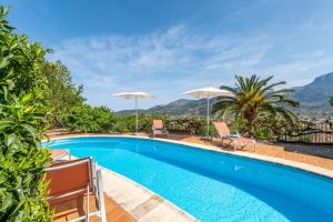 a swimming pool with two chairs and umbrellas at Can Jaumins in Sóller