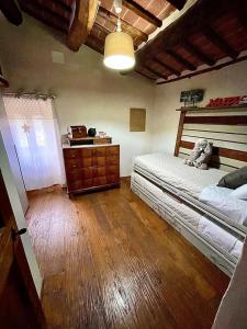 a bedroom with two beds and a dresser in it at Pergaccio Deluxe House in Cortona