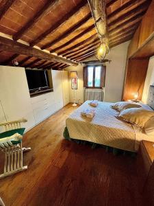 a bedroom with a large bed and a wooden floor at Pergaccio Deluxe House in Cortona