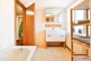 uma casa de banho com uma banheira, um lavatório e um espelho. em Ferienappartements Stralsund em Stralsund