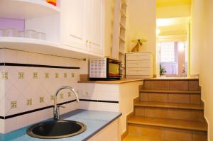 uma pequena cozinha com um lavatório e uma escadaria em Casa Tonia San Cesareo em Sorrento