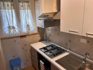 a small kitchen with a stove and a sink at Alghero Charming Apartments, Steps from the beach in Alghero