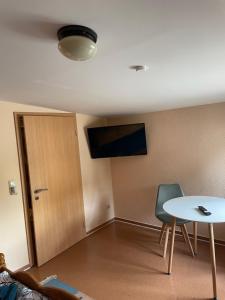 a room with a table and a tv on the wall at Zur zornigen Ameise in Thale