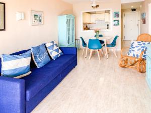 a living room with a blue couch and a table at ESPACIO 15 - Primera Línea de Playa in Cullera