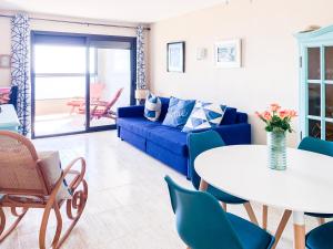 a living room with a blue couch and a table at ESPACIO 15 - Primera Línea de Playa in Cullera