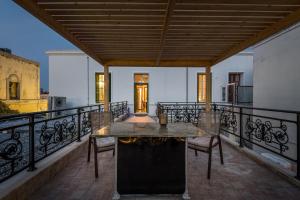 a patio with a table and chairs on a balcony at Casa Centrale Kos in Kos