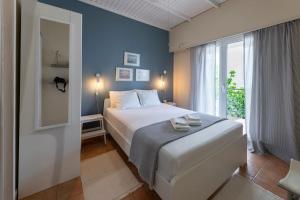 a bedroom with a bed and a large window at cosy house near the airport and the beach in Porto Rafti