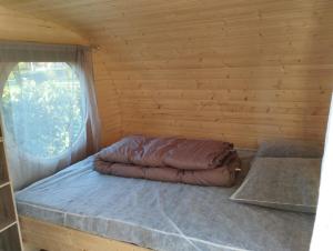 a bed in a log cabin with a window at camping des ribieres in Confolens