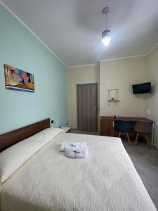 um quarto com uma grande cama branca e uma secretária em Casa Michele em Ercolano