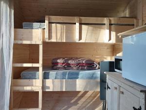 a wooden bunk bed in a kitchen with a refrigerator at camping des ribieres in Confolens +69 photos