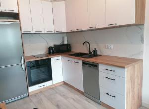 a kitchen with white cabinets and a sink and a stove at Apartament Pruszcz Gdański 1 in Pruszcz Gdański