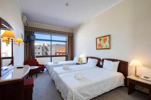 a hotel room with two beds and a window at Villa Fatima Hotel by Umbral in Fátima