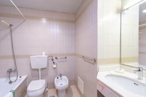 a bathroom with a toilet and a sink and a tub at Villa Fatima Hotel by Umbral in Fátima