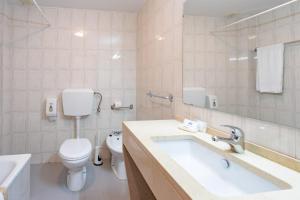 a white bathroom with a toilet and a sink at Villa Fatima Hotel by Umbral in Fátima