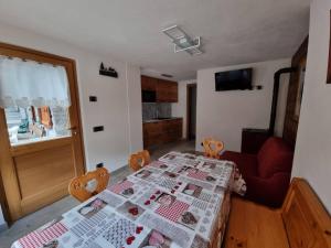 un soggiorno con tavolo e sedia rossa di Appartamenti Lucianaz a Rhêmes-Notre-Dame