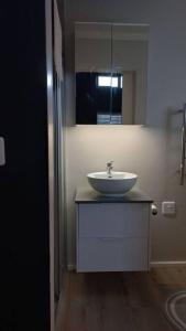 La salle de bains est pourvue d'un lavabo et d'un miroir. dans l'établissement A Superb apartment in Still Bay, à Stilbaai