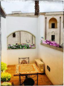 un patio con una mesa y una ventana con flores en La Piazzetta, en Nardò
