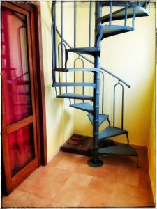 Una escalera de caracol en una habitación junto a una puerta en La Piazzetta, en Nardò