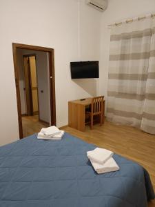 Serravalle Pistoiese的住宿－Hotel Alba Serravalle，客房设有一张蓝色的床、一张桌子和一台电视机