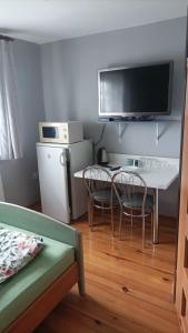 a living room with a table and chairs and a tv at Agroturystyka Pod Kogutem in Zamość