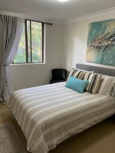 a large bed in a bedroom with a large window at Gosfords Best Location with Views in Gosford +37 photos