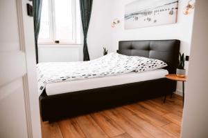 a small bedroom with a bed with a black headboard at Apartament LOFT na Moniuszki in Radom