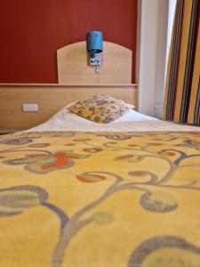 ein Schlafzimmer mit einem Bett mit einer bunten Decke in der Unterkunft Hotel Montana in De Panne