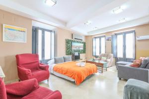 a living room with a bed and a couch and chairs at Apartamento DUPLEX SAGASTA in Seville