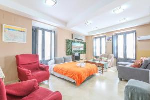 een woonkamer met een bed, een bank en stoelen bij Apartamento DUPLEX SAGASTA in Sevilla