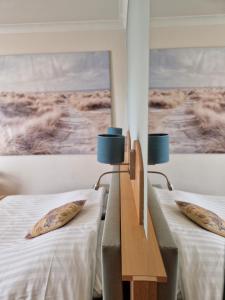ein Zimmer mit 2 Betten mit Kissen darauf in der Unterkunft Hotel Montana in De Panne