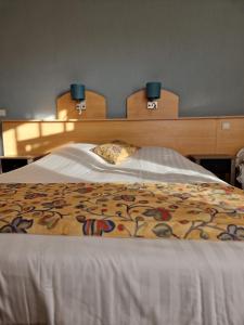 Schlafzimmer mit einem großen Bett mit einem Kopfteil aus Holz in der Unterkunft Hotel Montana in De Panne