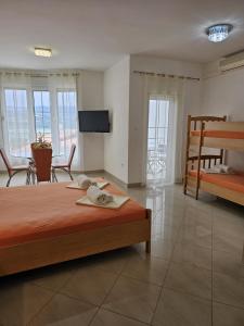 a bedroom with two beds and a living room with a television at Apartmani Barnjak in Trogir