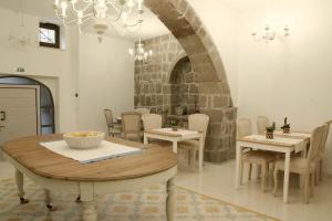 uma sala de jantar com mesas e cadeiras e um lustre em PALAZZO ALESSANDRINI GUEST HOUSE em Viterbo