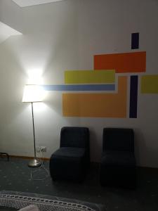 two chairs and a lamp in a room with a colorful wall at Firenze inn 21 Florence in Florence