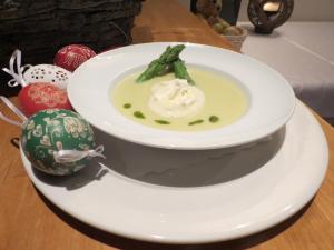a plate with a bowl of soup on a table at Hotel Aquamarin in Bad Mitterndorf