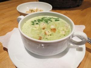 a white cup of soup on a plate on a table at Hotel Aquamarin in Bad Mitterndorf