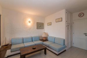 sala de estar con sofá azul y mesa en Corallina 179 - Happy Rentals, en Costa Corallina