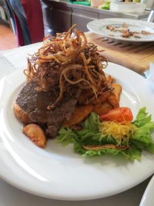 a plate of food with meat and vegetables on a table at Hotel Aquamarin in Bad Mitterndorf