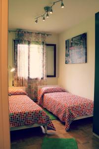 1 dormitorio con 2 camas y ventana en Appartamento alle Terme, en Abano Terme