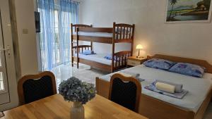 ein Schlafzimmer mit einem Etagenbett und einem Esstisch in der Unterkunft Apartmani Barnjak in Trogir