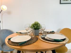 默倫的住宿－Le Cocon Melunais，一张木桌,上面有盘子和玻璃杯