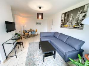 默倫的住宿－Le Cocon Melunais，客厅配有蓝色的沙发和桌子