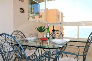 a dining room table with chairs and wine bottles on it at Apolo 11 vistas al mar garaje y wifi in Calpe