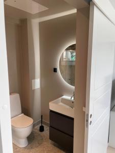 ein Badezimmer mit einem WC, einem Waschbecken und einem Spiegel in der Unterkunft Apartment in Sollentuna Centrum 1205 in Sollentuna