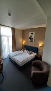 a bedroom with a large bed and a chair at BO Hotel Hamburg in Hamburg