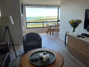 a living room with a table and a living room with a view at Superb accommodation in Stilbaai in Stilbaai