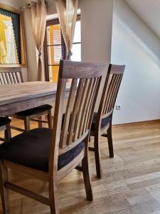 comedor con mesa de madera y sillas en Ferienwohnungen Pesenbachtal en Herzogsdorf