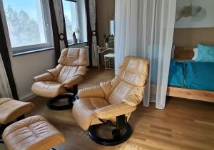 een woonkamer met 2 stoelen en een bed bij Ferienwohnungen Pesenbachtal in Herzogsdorf