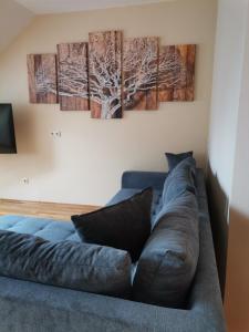 ein blaues Sofa in einem Zimmer mit drei Gemälden an der Wand in der Unterkunft Ferienwohnungen Pesenbachtal in Herzogsdorf