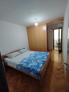 Apartment in Budva في بودفا: غرفة نوم عليها سرير وبطانية زرقاء